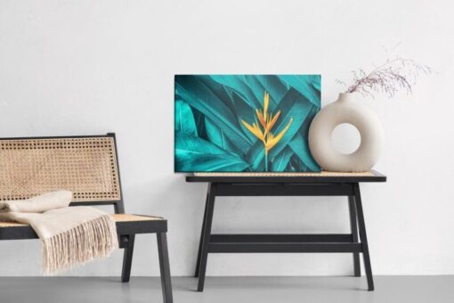 Leinwandbild Orange Blume Auf Einem Hintergrund Von Tropischen Blättern